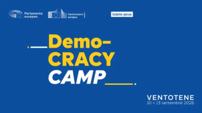 grafica dedicata all'iniziativa: sfondo blu con "Democracy Camp" in giallo e bianco